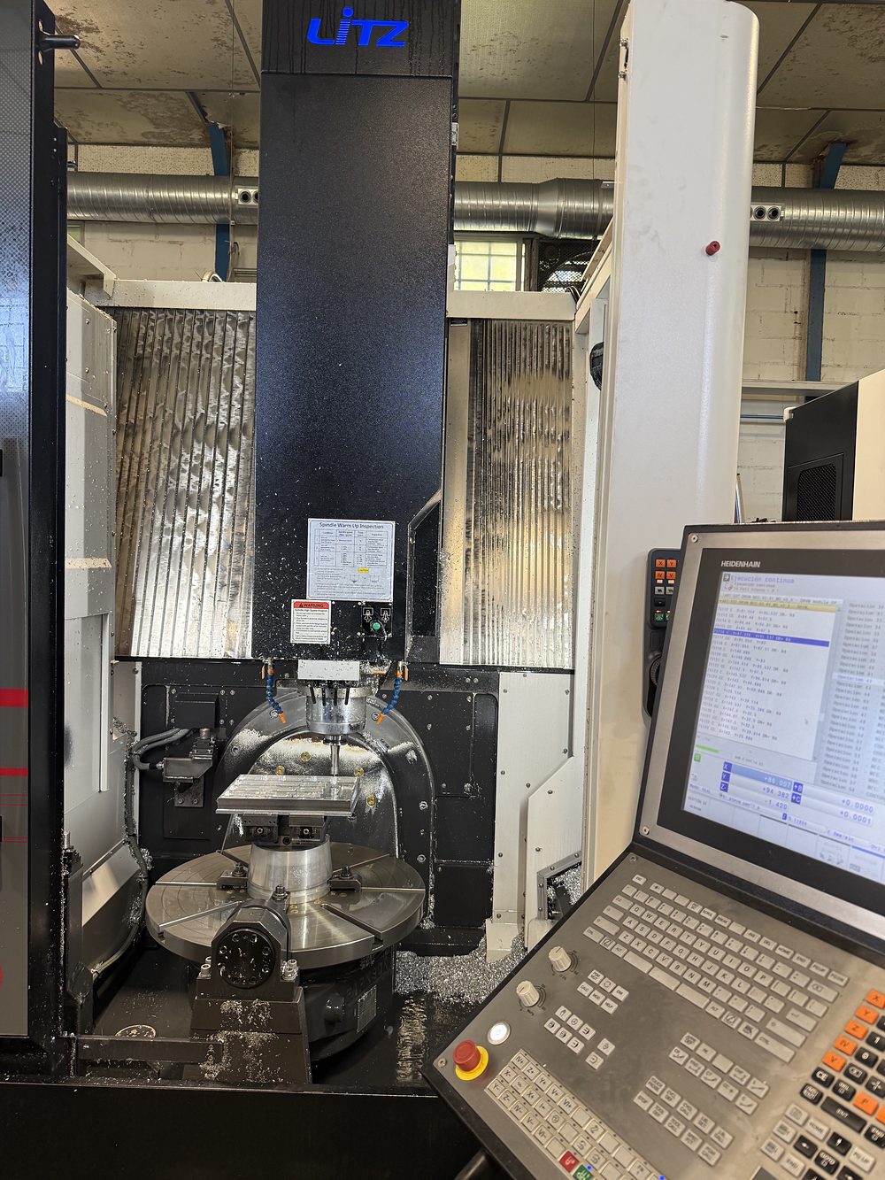 Centro de mecanizado de 5 ejes Litz con control Heidenhain, mecanizando una pieza de aluminio